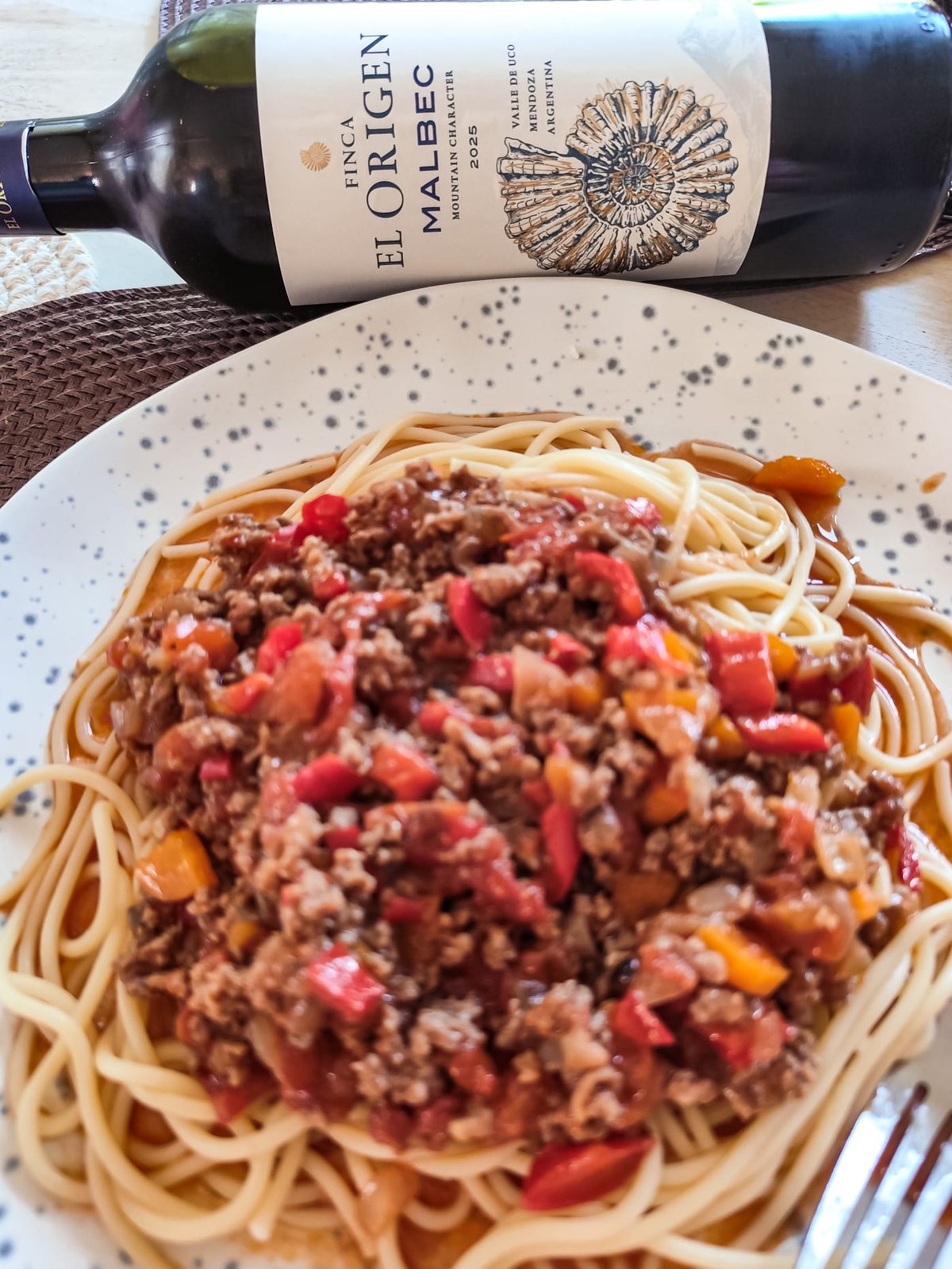 Finca El Origen Malbec 2025 z Doliny Uco obok spaghetti z sosem mięsnym i papryką